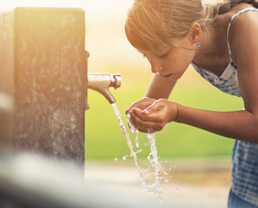 Child drinking from tap